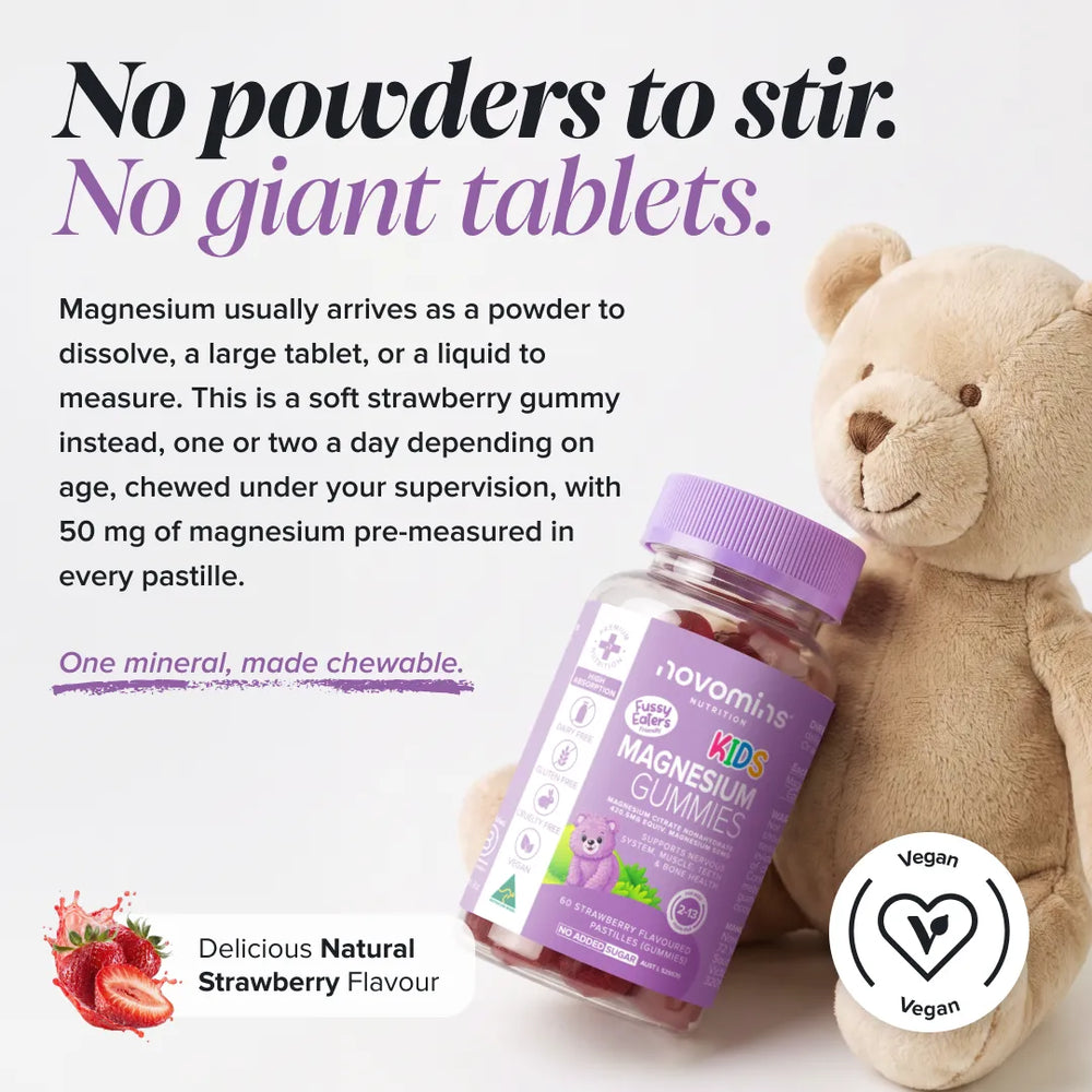 A bottle of Novombis Kids Magnesium Gummies displayed next to a beige teddy bear on a white background, with promotional text highlighting strawberry flavor and a vegan badge.